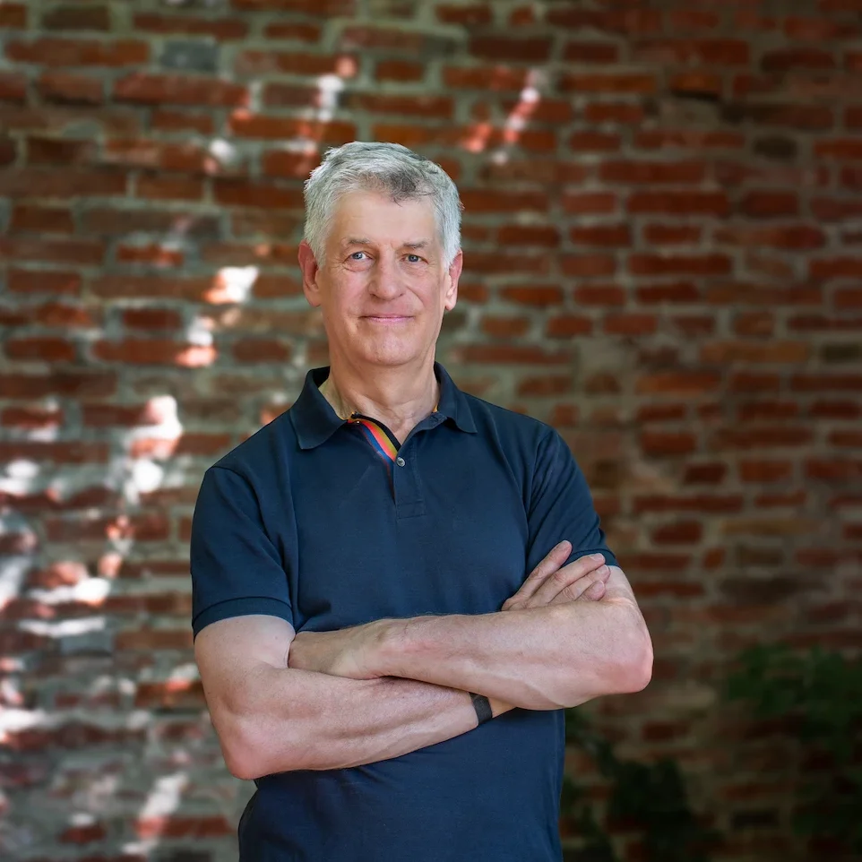 Tim Clark, Meditationslehrer, lächelnd im Porträt vor ruhigem Hintergrund
